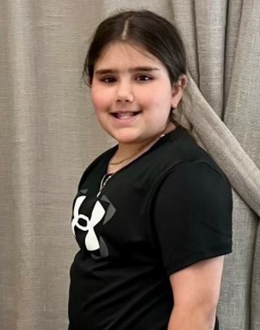 Photo of a smiling girl standing in profile